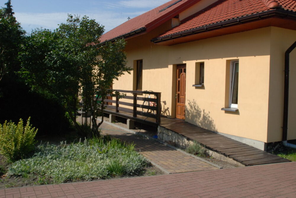 Wejście do domu i drewniany taras nad ogrodem
